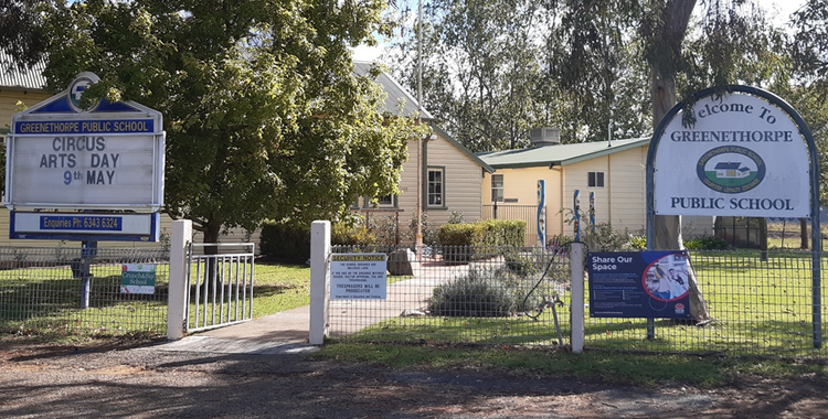 front view of our school, showing buildings, signs and grassed area